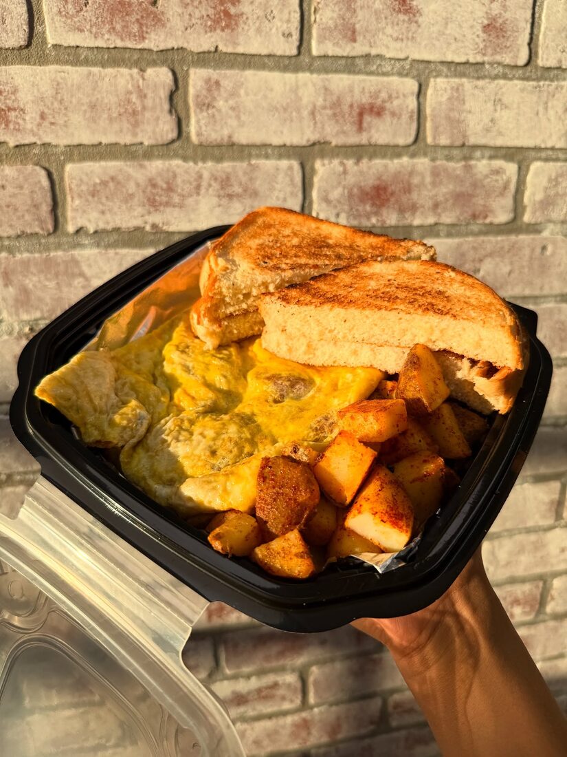 A loaded breakfast platter with eggs, grilled toast, and home fries